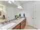 Well-lit bathroom with double sinks, granite countertop, and wood cabinets at 7572 Viola Loop, Lakewood Ranch, FL 34202