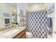 Bathroom with a granite countertop vanity, toilet, and shower featuring a patterned curtain at 7572 Viola Loop, Lakewood Ranch, FL 34202
