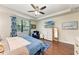 Stylish main bedroom featuring a ceiling fan, hardwood floors, and a scenic window with natural light at 7572 Viola Loop, Lakewood Ranch, FL 34202