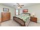 Comfortable bedroom featuring wooden furnishings, a ceiling fan, and warm, inviting lighting at 7572 Viola Loop, Lakewood Ranch, FL 34202