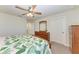 Bedroom with tropical bedding, ceiling fan, and view to the entry and bathroom at 7572 Viola Loop, Lakewood Ranch, FL 34202
