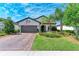 Charming one-story home featuring a well-manicured lawn, paver driveway, and a welcoming two-car garage at 7572 Viola Loop, Lakewood Ranch, FL 34202