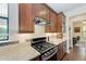 Modern kitchen with stainless steel appliances, granite countertops, and dark wood cabinetry at 7572 Viola Loop, Lakewood Ranch, FL 34202