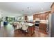 Open-concept kitchen with a large island, pendant lighting, stainless steel appliances, and hardwood floors at 7572 Viola Loop, Lakewood Ranch, FL 34202