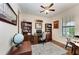 Well-lit office space with hardwood floors, built-in bookcases, and a comfortable work area at 7572 Viola Loop, Lakewood Ranch, FL 34202