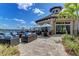 Charming outdoor dining area with comfortable seating, umbrellas, and views of the water at 7572 Viola Loop, Lakewood Ranch, FL 34202