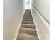 Carpeted staircase with white painted handrail leads to the upper level of the home at 7572 Viola Loop, Lakewood Ranch, FL 34202