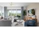 Living room with sectional sofa, large windows, and access to balcony at 9973 Key Haven Rd, Seminole, FL 33777