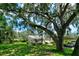 Home exterior showcasing landscaping and large oak tree at 3447 Tallywood Ln # 7143, Sarasota, FL 34237