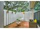 Private brick patio with white fence and hanging planters at 3447 Tallywood Ln # 7143, Sarasota, FL 34237