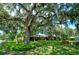 House exterior showcasing landscaping and large oak tree at 3447 Tallywood Ln # 7143, Sarasota, FL 34237