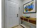 Bright entryway with white door, console table, and modern art at 3447 Tallywood Ln # 7143, Sarasota, FL 34237
