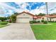 Exterior view of a single story home with a two-car garage and well manicured lawn at 5042 Clubview E Ct, Bradenton, FL 34203