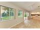 Sunroom with tile floors, view of kitchen, and access to backyard at 5042 Clubview E Ct, Bradenton, FL 34203