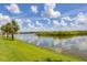Serene waterfront view with palm trees and clear blue skies at 10520 Boardwalk Loop # 605, Lakewood Ranch, FL 34202
