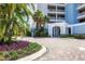 Condo building entrance with lush landscaping and brick driveway at 10520 Boardwalk Loop # 605, Lakewood Ranch, FL 34202