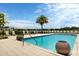 Refreshing resort-style pool with surrounding lounge chairs and palm trees at 10520 Boardwalk Loop # 605, Lakewood Ranch, FL 34202