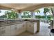 Outdoor kitchen with granite countertops and white cabinets at 10520 Boardwalk Loop # 605, Lakewood Ranch, FL 34202