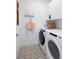 Bright laundry room with washer, dryer, and patterned tile floor at 9975 Key Haven Rd, Seminole, FL 33777