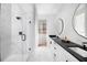 Spa-like bathroom with a walk-in shower, double vanity, and marble finishes at 9975 Key Haven Rd, Seminole, FL 33777
