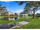Curved walkway along a pond with reflecting building and fountain at 9973 Key Haven Rd, Seminole, FL 33777