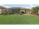 View of the backyard with a screened-in patio and green lawn at 10132 Colubrina Dr, Venice, FL 34293