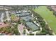 Aerial view showcases meticulously maintained tennis courts, lush landscaping, and the adjacent golf course at 12663 Fontana Loop, Bradenton, FL 34211
