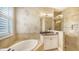 Bright bathroom featuring a soaking tub, tiled shower, and stylish vanity at 12663 Fontana Loop, Bradenton, FL 34211