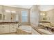 Elegant bathroom featuring double sinks, a soaking tub, and neutral decor at 12663 Fontana Loop, Bradenton, FL 34211