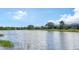 Peaceful lake view showcasing the surrounding community homes against a clear blue sky at 12663 Fontana Loop, Bradenton, FL 34211