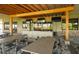 Inviting outdoor bar area featuring a covered patio, ample seating, and modern televisions for entertainment at 12663 Fontana Loop, Bradenton, FL 34211