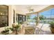Covered patio features travertine tile, seating, ceiling fan, and panoramic views of pool and lake at 12663 Fontana Loop, Bradenton, FL 34211