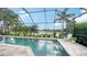 Screened-in pool area with comfortable seating, lush landscaping, and a tranquil lake view at 12663 Fontana Loop, Bradenton, FL 34211