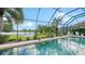 Screened-in pool with lush landscaping and seating overlooking a peaceful lake at 12663 Fontana Loop, Bradenton, FL 34211