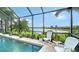 Relaxing poolside view with white chairs, beautiful landscaping, and a tranquil lake backdrop at 12663 Fontana Loop, Bradenton, FL 34211