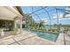 Screened-in pool overlooking a serene lake, surrounded by palm trees and manicured landscaping at 12663 Fontana Loop, Bradenton, FL 34211