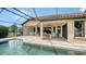 Back of home features a covered patio, pool, and manicured lawn at 12663 Fontana Loop, Bradenton, FL 34211