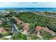 Aerial view of home in a residential community with a large tree in the front yard, surrounded by lush greenery at 264 Woods Point Rd, Osprey, FL 34229
