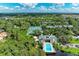 Expansive aerial view displays community with tennis courts and a pool set amongst lush greenery and nature at 264 Woods Point Rd, Osprey, FL 34229