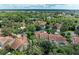 Expansive aerial view of a community with lush greenery and a variety of beautiful homes featuring terracotta roofs at 264 Woods Point Rd, Osprey, FL 34229
