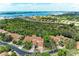 Stunning aerial view showcasing lush landscaping, red tile roofs, and the expansive bay in the background at 264 Woods Point Rd, Osprey, FL 34229