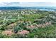 Scenic aerial view captures the community's layout with lush trees, tennis courts, and nearby water views at 264 Woods Point Rd, Osprey, FL 34229