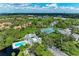 Extensive community real estate with pool, tennis courts and lush landscaping from an aerial perspective at 264 Woods Point Rd, Osprey, FL 34229