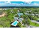 Overhead view featuring community pool and tennis courts, surrounded by lush landscaping and mature trees at 264 Woods Point Rd, Osprey, FL 34229