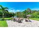 Serene outdoor amenity area with pond view, features brick fire pit and benches for community enjoyment at 264 Woods Point Rd, Osprey, FL 34229