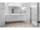 Bright bathroom with double vanity, large mirror, and glass-enclosed shower at 264 Woods Point Rd, Osprey, FL 34229