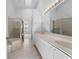 Well-lit bathroom with a double vanity, glass-enclosed shower, and neutral tile at 264 Woods Point Rd, Osprey, FL 34229