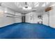 Spacious garage with ample storage cabinets, utility sink, and durable blue carpet at 264 Woods Point Rd, Osprey, FL 34229