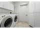 Laundry room with washer, dryer, cabinets, and tiled floor at 264 Woods Point Rd, Osprey, FL 34229