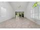 Spacious living room with tile flooring, fan, large windows and doors allowing access to the outdoors at 264 Woods Point Rd, Osprey, FL 34229